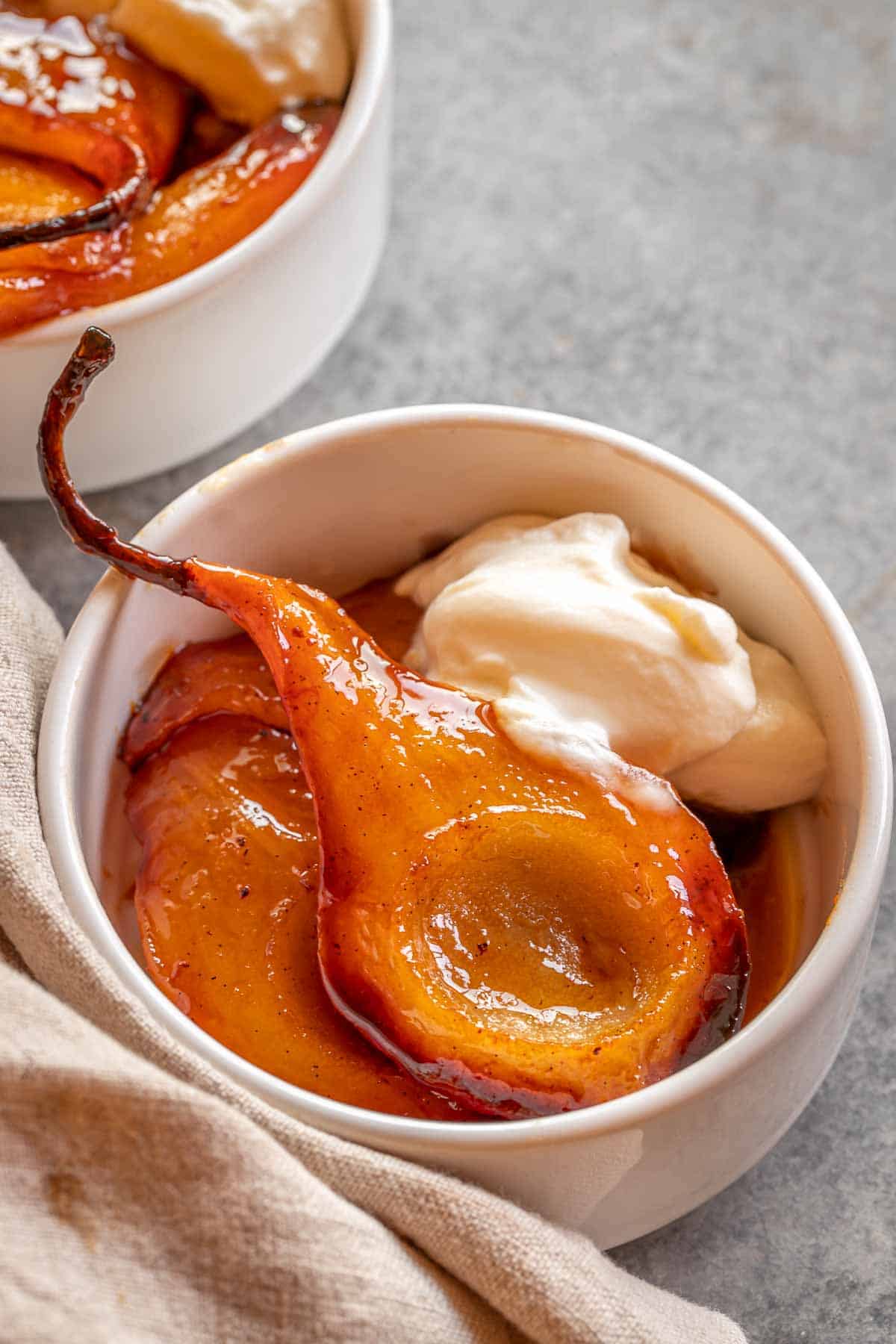 Baked pears with caramelized pear juice around, with yogurt on the side. 