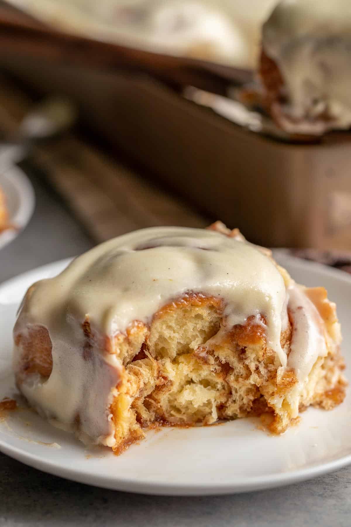 The best cinnamon rolls are soft, fluffy with plenty of the cinnamon sugar ribboned throughout and a heaping amount of cream cheese icing on top. It's a close up image of the cinnamon roll to show all of those.