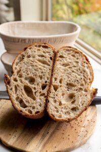 Sourdough Bread cut into half exposing the lacy interior crumb of the bread.