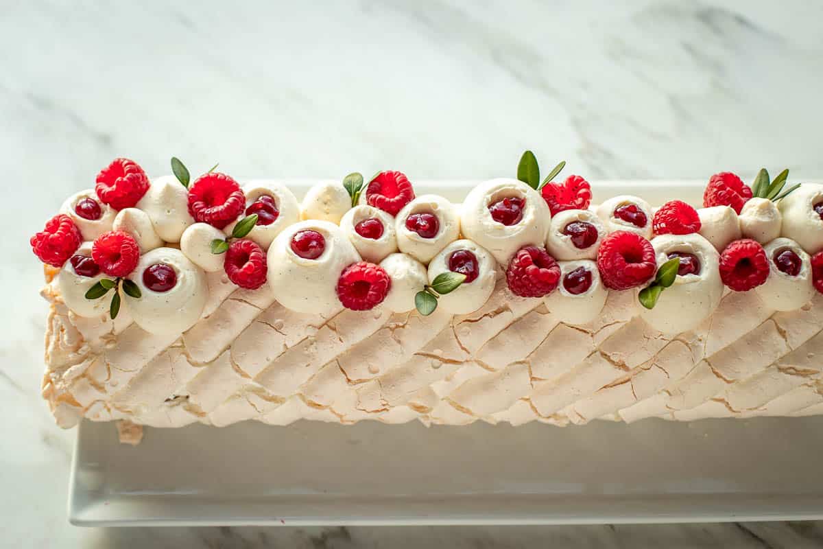 Top view of the meringue roulade on a plate and marble table top.
