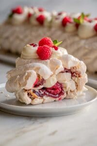 Side view of a piece of the meringue roulade on a plate.