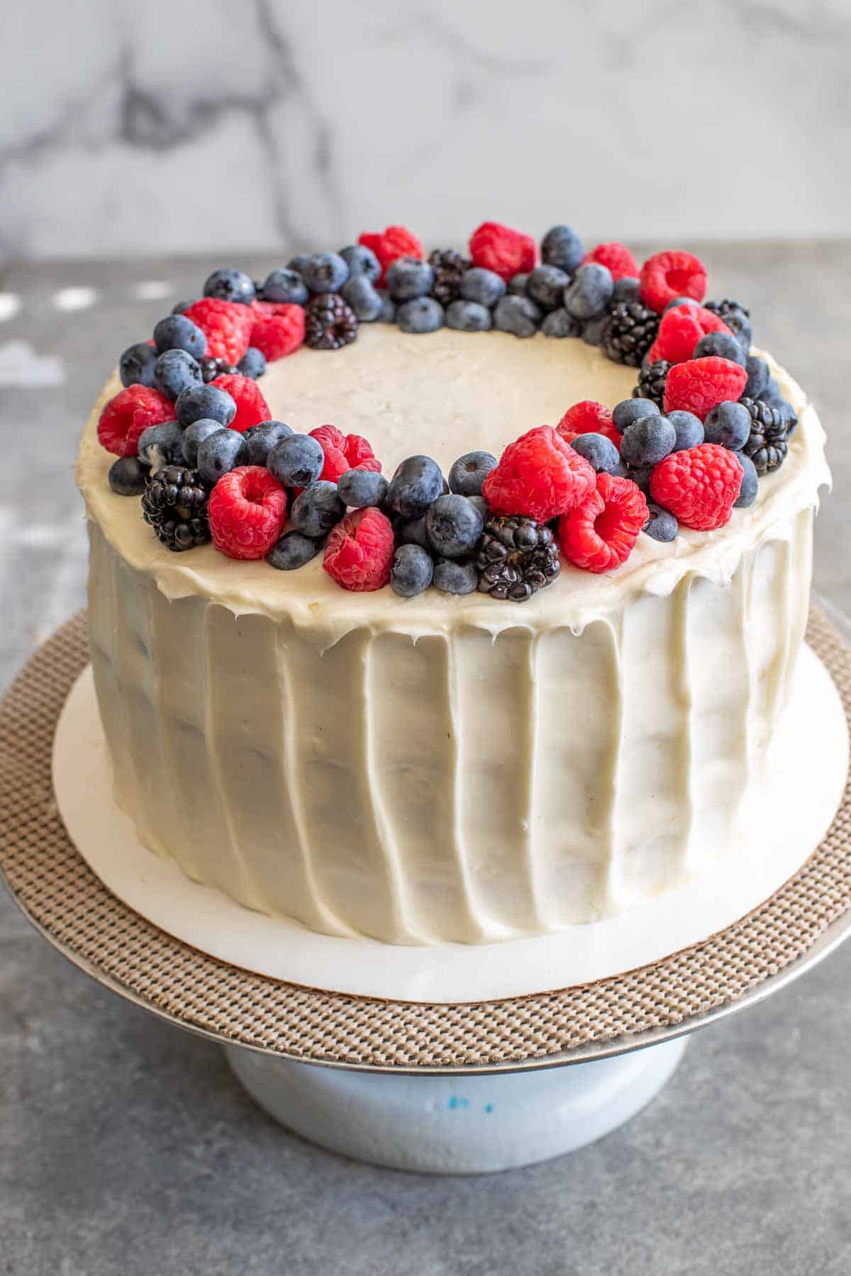Chantilly Cake with Berries arranged around the top perimeter, in a wreath shape. 