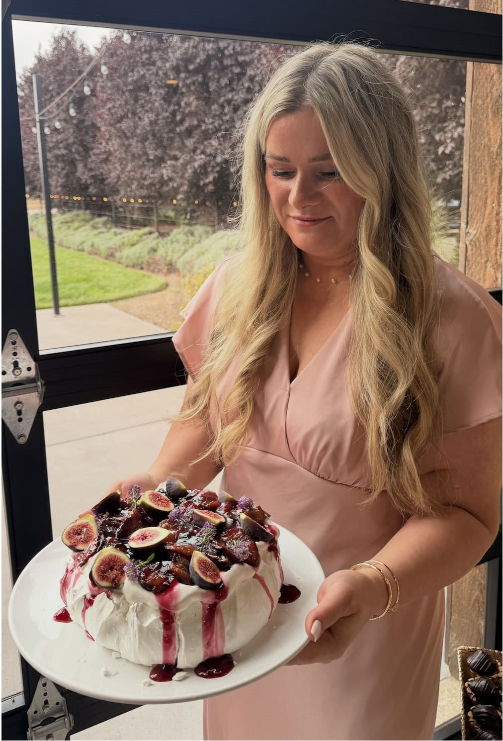 Marina, the author behind Let the Baking Begin, holding the roasted plum pavlova