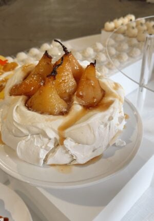 Roasted pear pavlova topped with whole caramelized pears and caramel