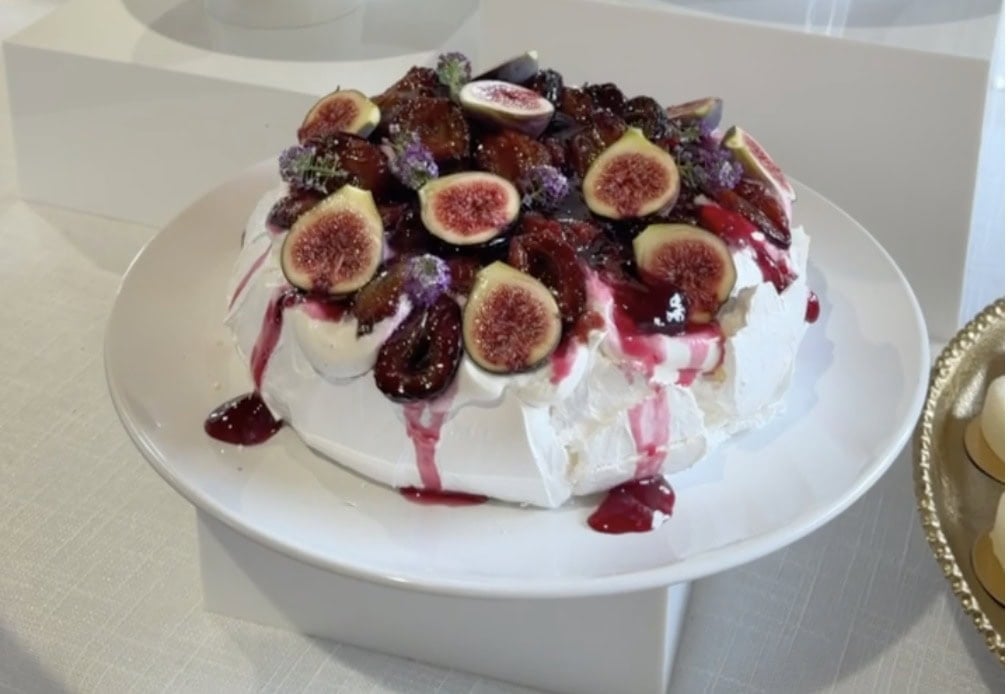 Roasted plum pavlova with figs on a dessert table