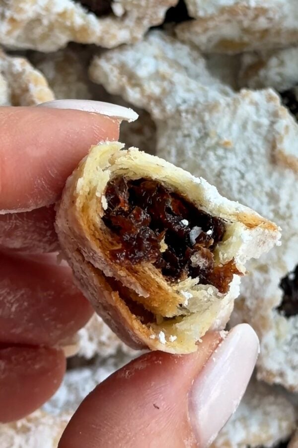 Rogaliki broken in half to show the flaky layers and thick plum butter filling