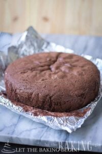 Chocolate sponge cake baked tall and level, on foil on a marble board