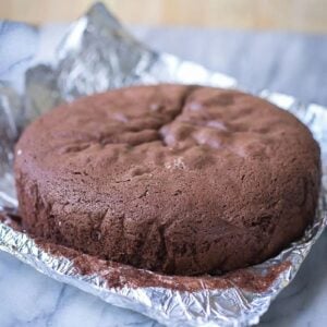 Chocolate sponge cake baked tall and level, on foil on a marble board