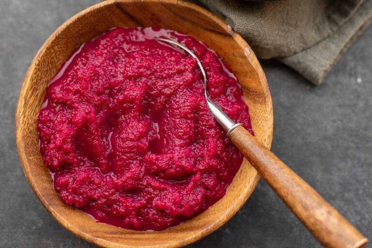 Homemade beet horseradish in a wooden bowl, top view
